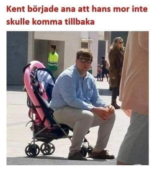 Man i blå skjorta och beige byxor sitter på en bänk bredvid en tom barnvagn utomhus.