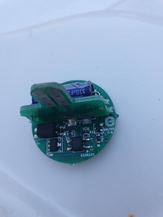 Elektronisk kretskort för lampa med komponenter och kondensator, behöver byte då röd färg inte fungerar.