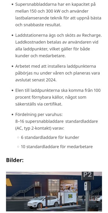 Elektrisk bil laddas vid en laddstolpe på parkering utanför affär med skyltar och släpvagn i bakgrunden.