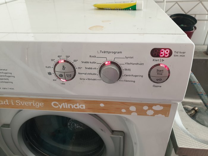 Tvättmaskins kontrollpanel med startat program och fel på displayen, varumärke Cylinda.