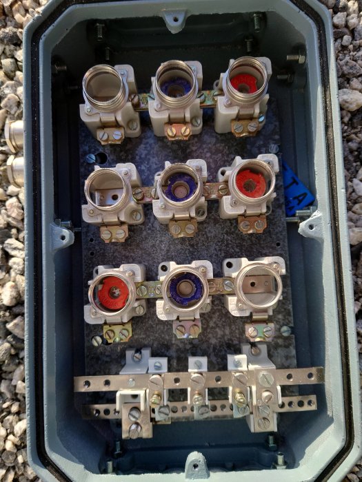 Öppen elektrisk undercentral med flera tomma kabelgenomföringar och kontakter.