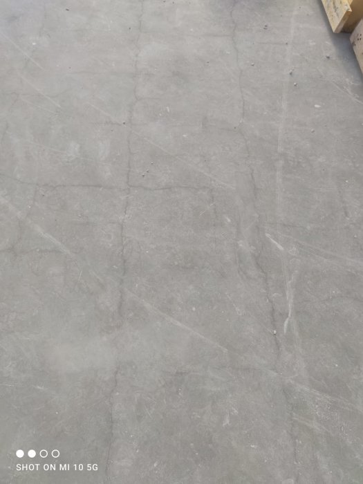 Grå betongyta med sprickor och märken, antydan till rektangulär form, inspelad med en MI 10 5G smartphone.