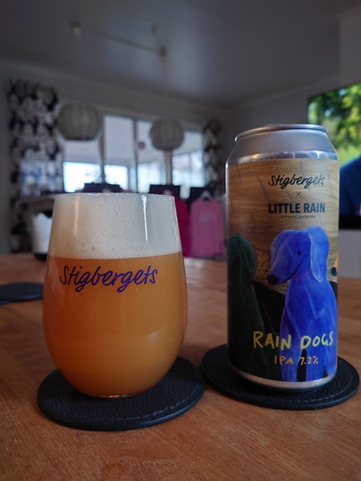 Ölglas märkt Stigbergets fyllt med öl och en ölburk med etikett "Stigbergets Little Rain" på ett bord.