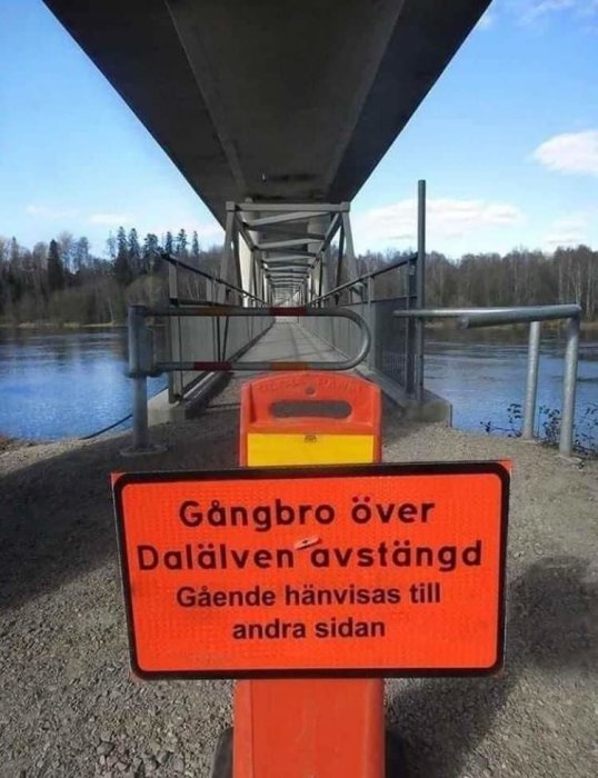 Skylt som informerar om avstängd gångbro över Dalälven med hänvisning för gående.