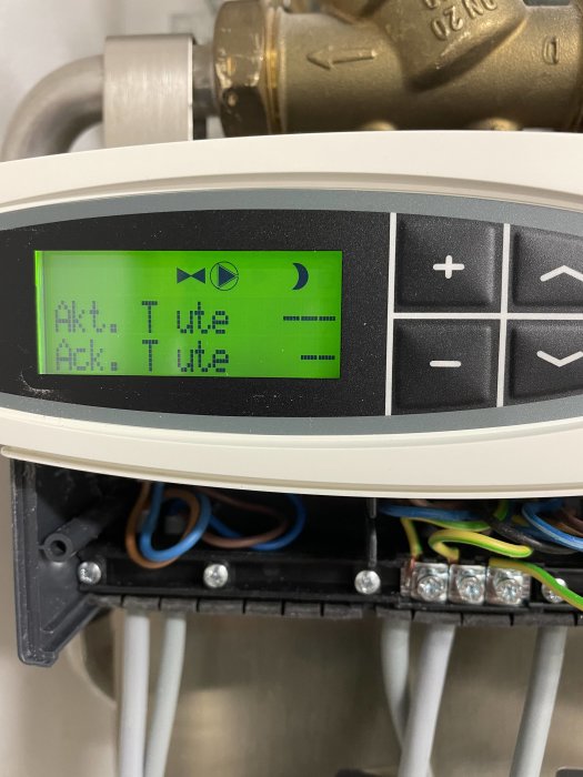 Givarens display på en vägg med aktuell och ackumulerad temperaturvisning, omgivet av elanslutningar.