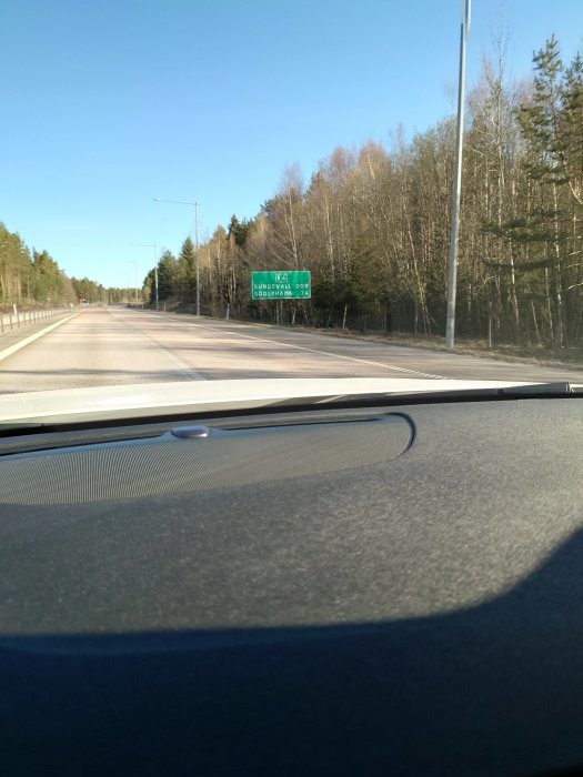 Vy från bil som närmar sig vägskylt längs E4, angivande avstånd till Sundsvall och Söderhamn.