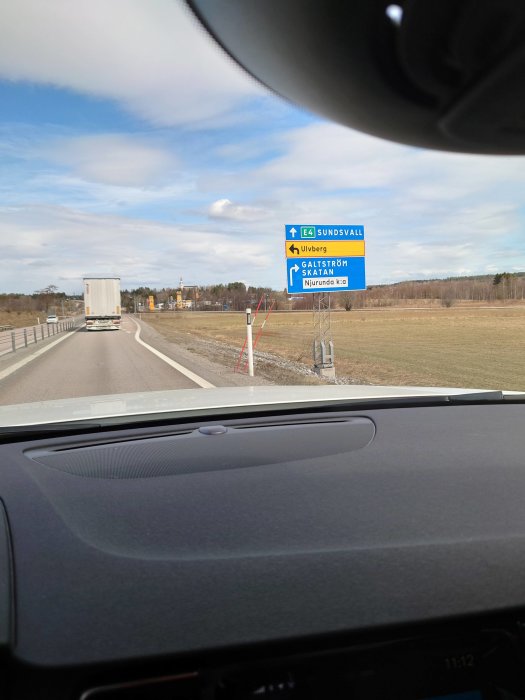 Vy från bil på väg, med trafikskylt som visar riktning mot Sundsvall via E4, avfart till Galtström och Såltjärn.