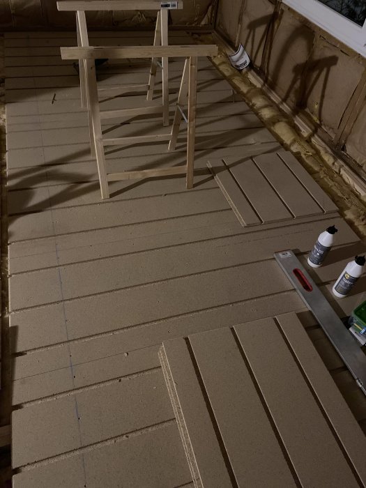 Underkonstruktion för golv med träreglar och isolering i ett pågående byggprojekt.