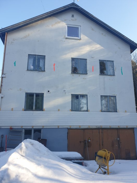 Husfasad med markeringar i rött och grönt för potentiella vägar för fasadbelysningsslangar.