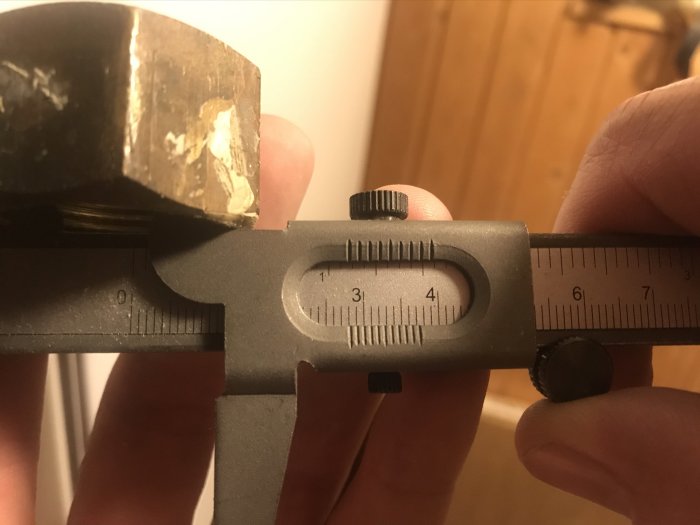 Skjutmått som mäter invändigt mått på en mutter, visar cirka 28mm.