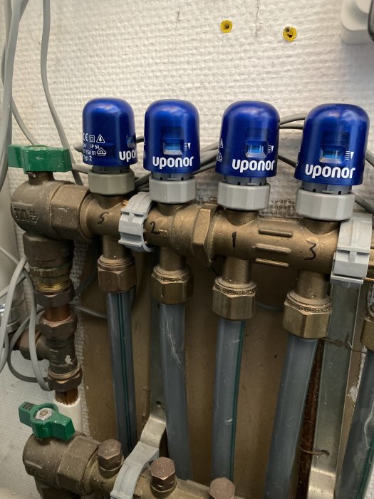 Värmefördelare med märkta reglage för badrum i en VVS-installation.