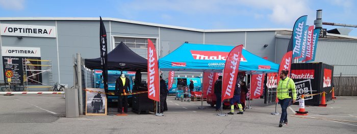 Makita roadshow utanför Optimera med tält, flaggor och kunder som handlar verktyg.