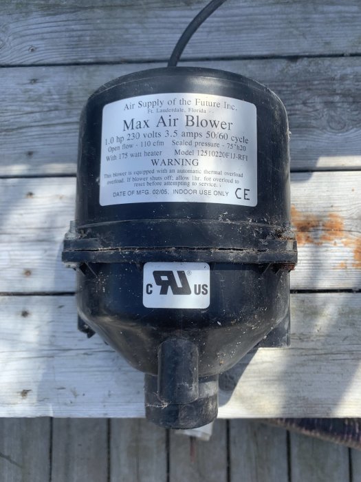Luftpump med etikett 'Max Air Blower' på en träyta, används för bubblor i en badtunna.