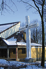 Unik värmepump som liknar ett kors framför en kyrka i snölandskap