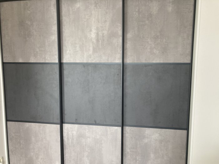 Nymonterade gråa skjutdörrar med elegant design i ett hemmiljö.