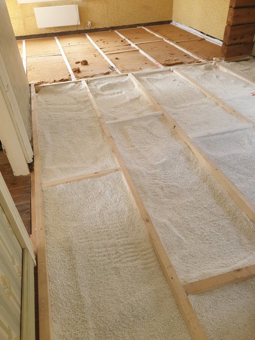 Reglat golv med makadam och perlite isolering mellan träreglarna, redo för golvläggning.