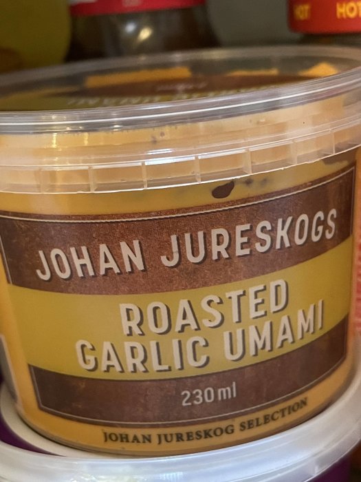 Burk med Johan Jureskogs Roasted Garlic Umami-sås på en hylla.