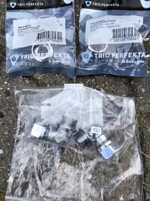 Metallrörkopplingar i plastförpackningar på marken, tillhörande ett VVS-projekt.