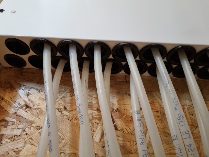 Installationsdetalj med flera PEX-rör som kommer ut ur en fördelare i ett golvvärmesystem.