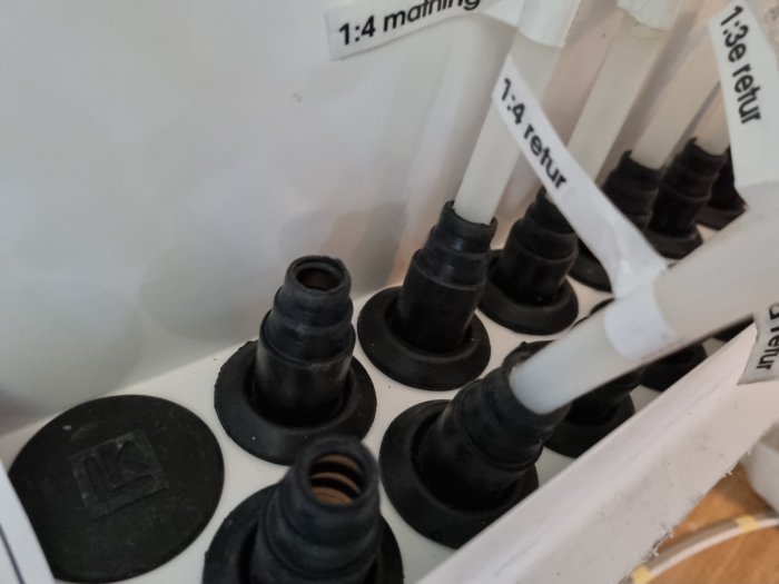 Närbild av sortiment av svarta genomföringshylsor i olika storlekar, märkta med vit text.