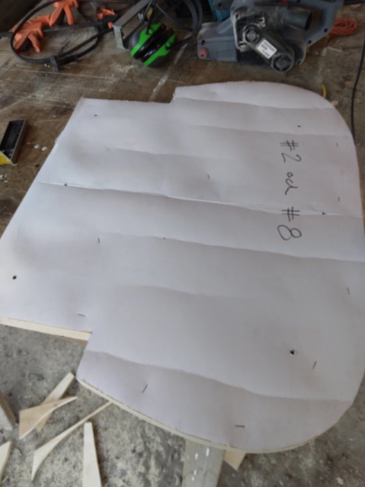 Utformad plywoodspantmall för kanadensare bygge, markerad med #2 och #8, på ett verkstadsbord med verktyg i bakgrunden.
