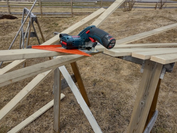 Bosch såg på träplanka vid staketbygge utomhus.