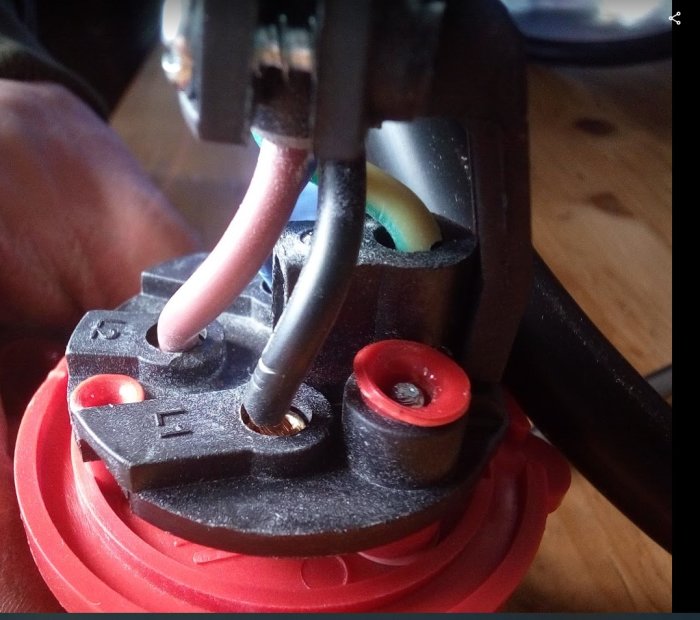 Närbild på en 4-pinnars svetshandske med kopplade kablar och synlig skyddsjord.