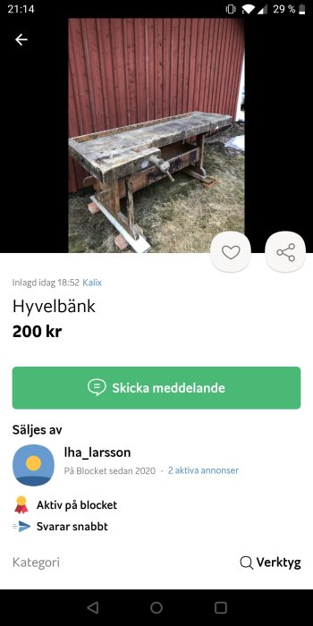 Begagnad hyvelbänk i trä framför röd trävägg, till salu för 200 kr.