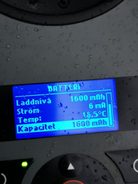 LCD-display på en robotgräsklippare som visar full batterikapacitet på 1600 mAh och en temperatur på 16,5°C.