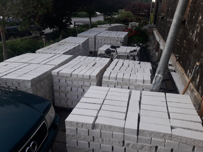 Isoleringsblock staplade utomhus nära ett pågående fasadrenoveringsprojekt.