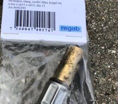 Stödhylsa i botten på en klämringskoppling, förpackad, plus etikett med produktdetaljer.