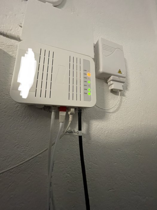 Fibermodul med anslutna kablar; en märkt för Google WiFi, en oanvänd, en till värmepump, en till gästhus.