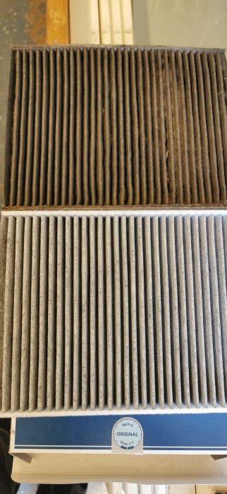 Gamla och nya luftfilter jämförs, det övre filtret är smutsigt och det undre är rent.