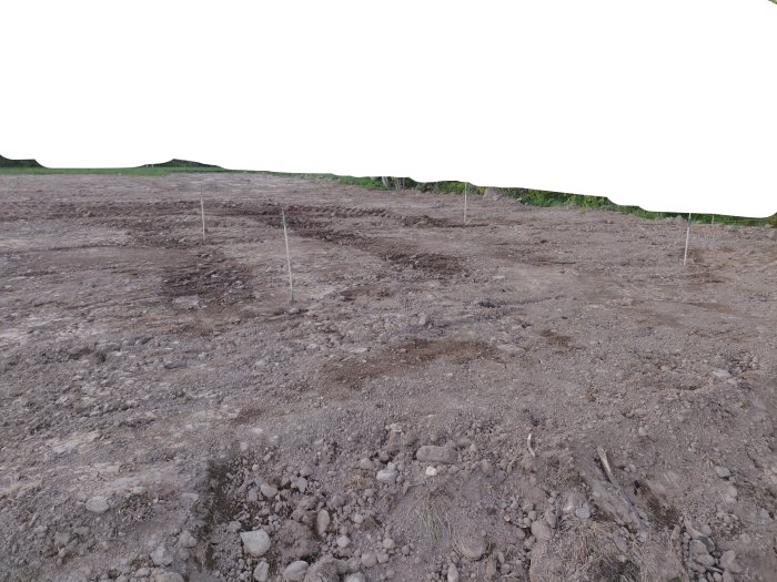 Uppschaktad tomt för framtida friggebod med synliga nivåskillnader och märkta hörnpunkter