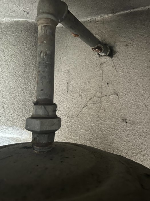 Röranslutning på en gammal varmvattenberedare som kan vara problemet beskrivet i inlägget.