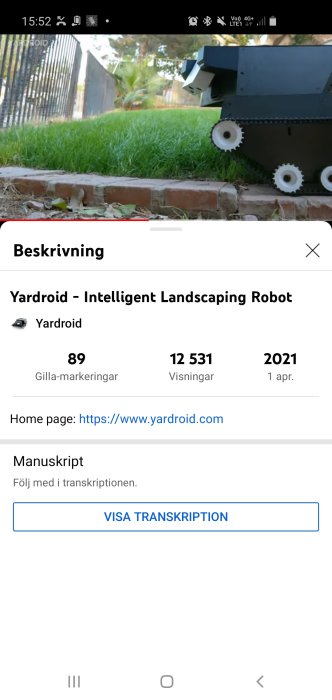 Robot för trädgårdsskötsel på gräsmatta nära röd tegelkant.