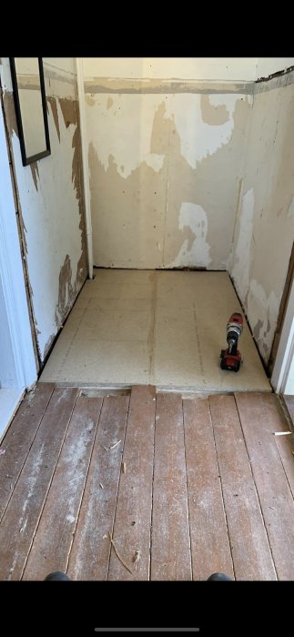 Golvrenovering med ny spånskiva ovanpå bjälklaget och gammalt, men stabilt, trägolv nära trappa.