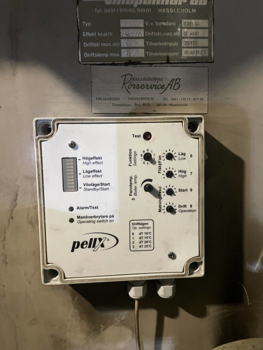 Pelletsbrännarens styrbox av märket Pellx monterad på en vägg med olika reglage och inställningar.