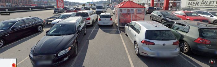 Parkeringsplats med blandade fordon, övervägande kombibilar, vid en stormarknad.