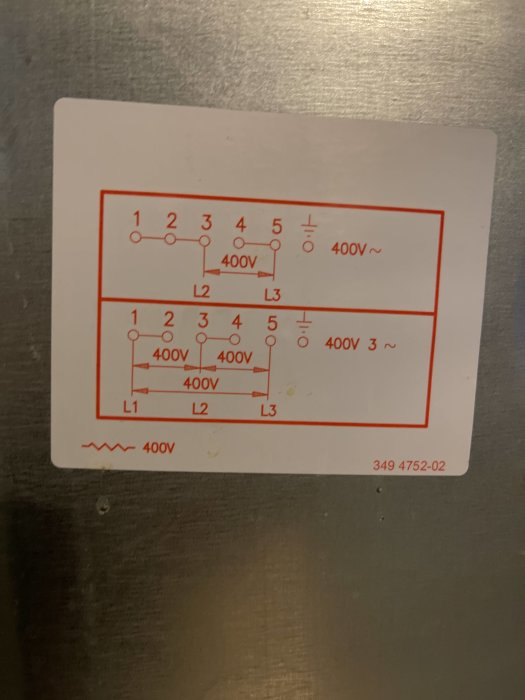 Elkopplingsschema för trefassystem på en etikett med anvisningar för 400V-kopplingar.