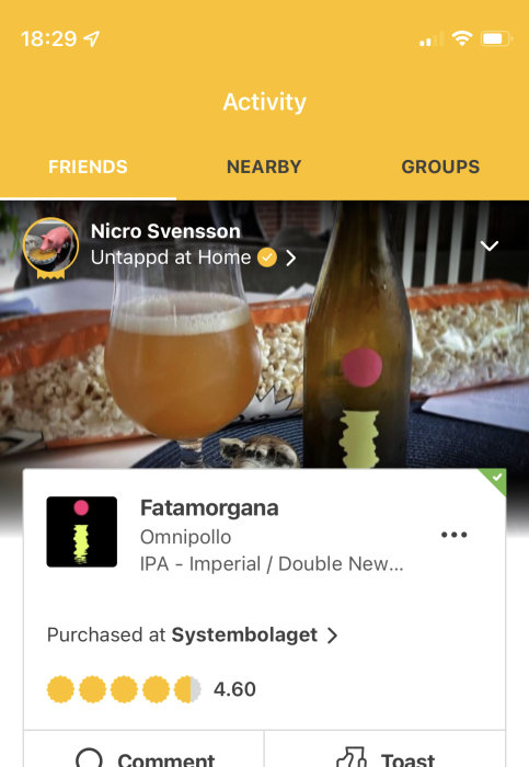 Ölglas med IPA och en popcornskål i bakgrunden på en mobilappskärm.