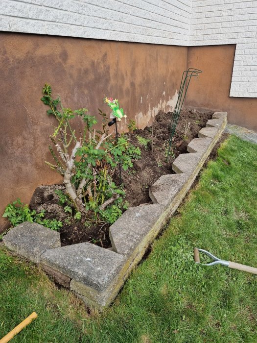 En nyligen rättad knäckstensmur med fyra lager stenar längs en trädgårdskant.