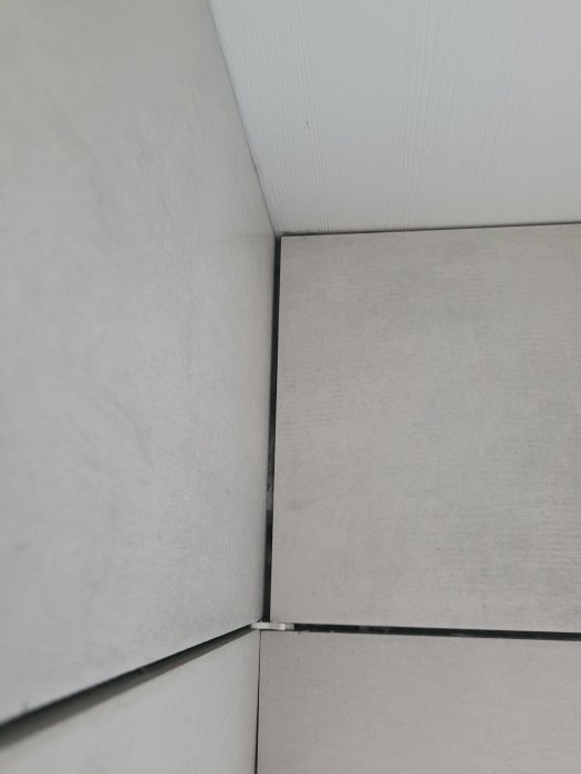 Kaklade väggar med ojämn fog och 4-5mm glipa mellan plattorna i hörnet.