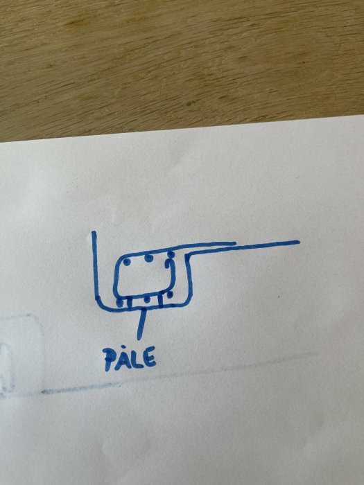 Handritad skiss som visar en påle med armeringsjärn och en kantbalksbygel i överkanten.