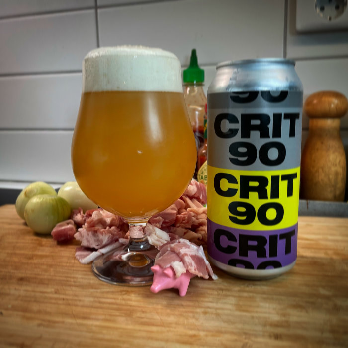 Ölglas med skum vid klippning av skinka och ölburk med texten "CRIT 90".