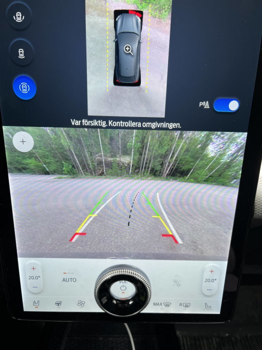 Bilens infotainmentskärm visar 360-graders kamerautsikt med varningslinjer och bilmodell.