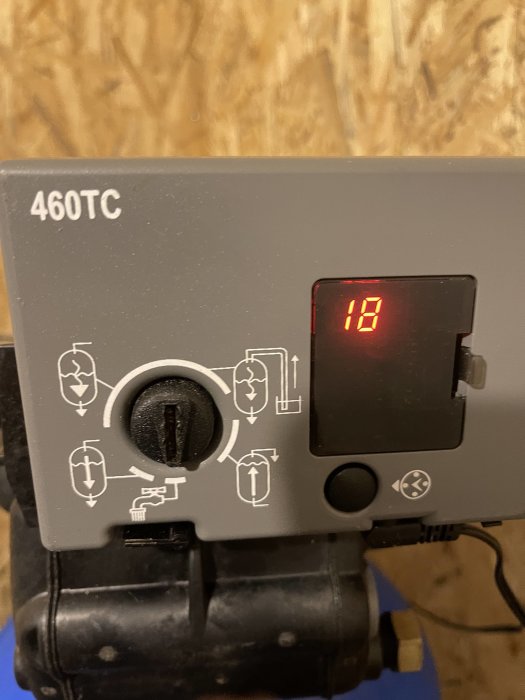 Närbild på en kontrollpanel för vattenfilter märkt "460TC" med röd digital display visar siffran 18.