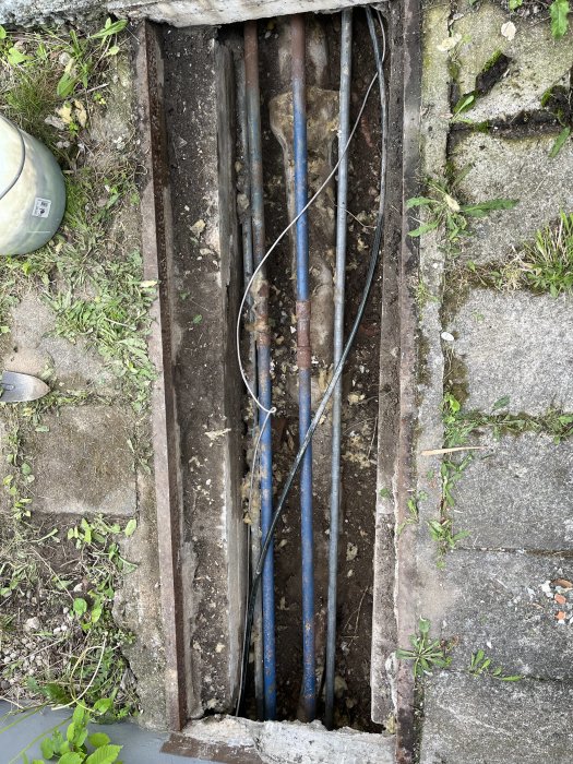 Äldre kulvert med synliga rörledningar och kablar, behöver isolering och renovering.