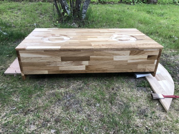 Unfinished wooden seat base for a house bus with rotational fittings and two circular marks for chair installation.