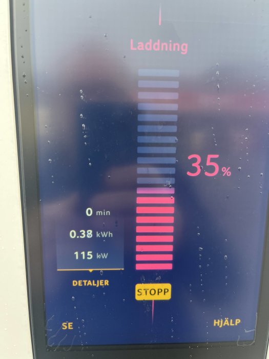 Laddningsdisplay visar 35% batterinivå med en effekt på 115 kW under en elbilsladdning.